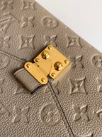 Louis Vuitton monogram leather flap close-up with gold clasp and textured surface