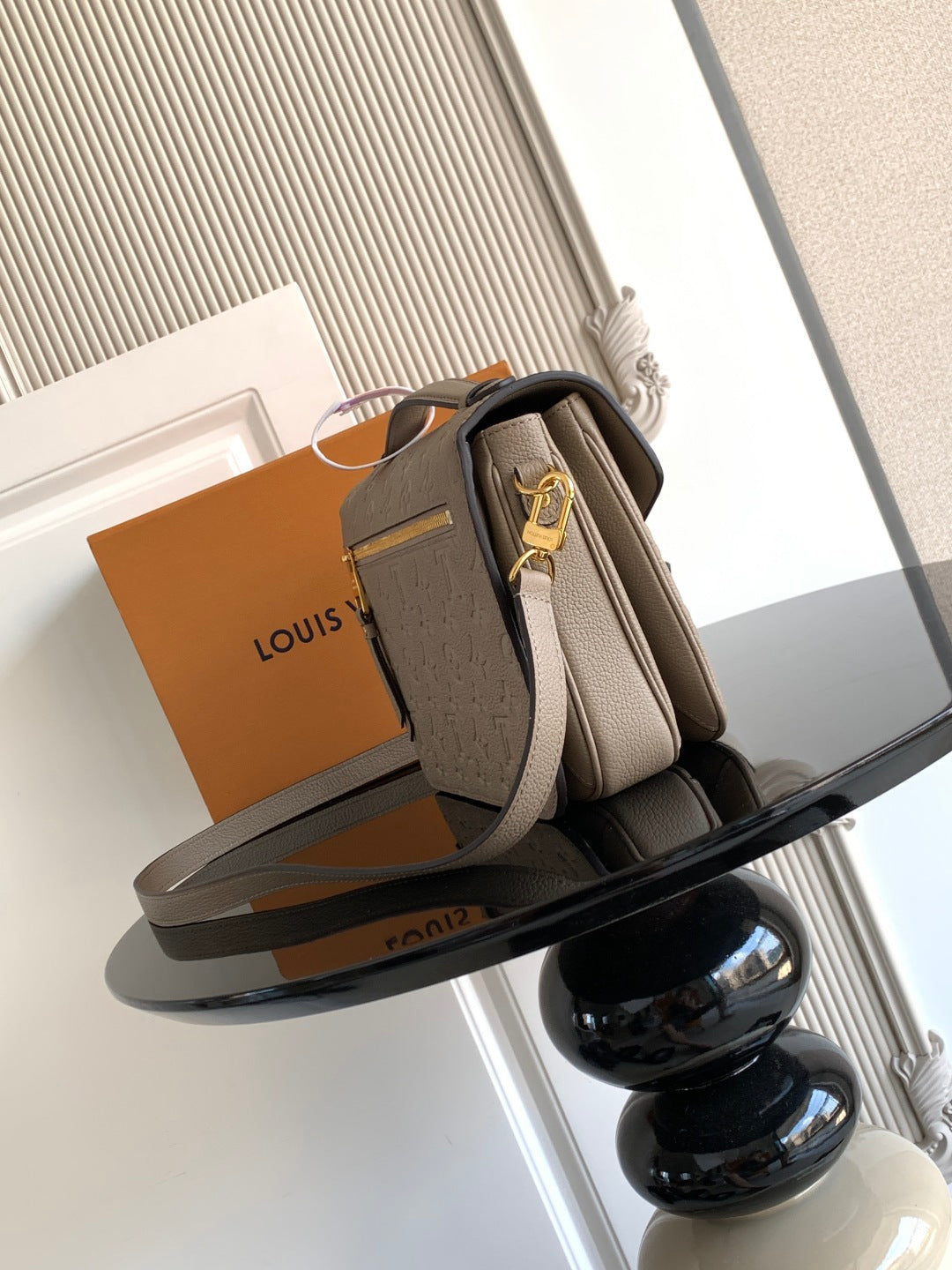Louis Vuitton monogram crossbody bag in taupe with flap, side view, gold-tone hardware