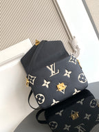 Louis Vuitton monogram crossbody bag in dark navy with gold emblem and adjustable strap.