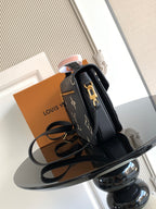 Louis Vuitton monogram crossbody bag with structured black leather, gold clasp, and strap.