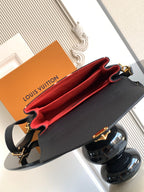 Louis Vuitton crossbody bag open to show red interior lining and dark exterior with gold hardware.