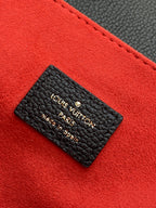 Louis Vuitton Paris made in Spain leather label card on red fabric background.