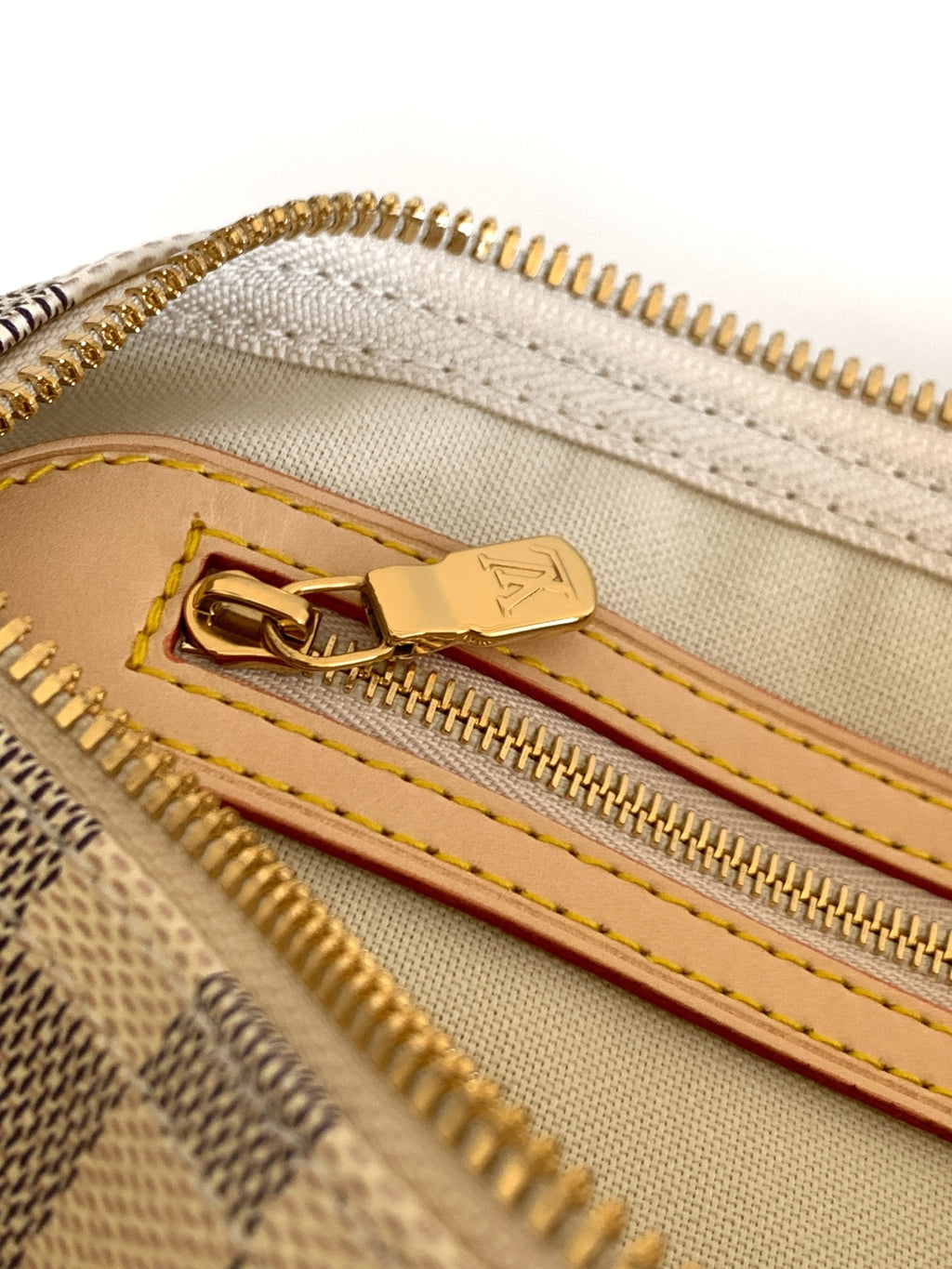 Louis Vuitton checkerboard bag zipper close-up with leather pull and gold teeth