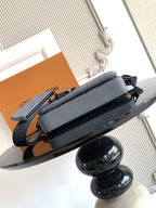 Louis Vuitton monogram satchel bag, gray top flap with long black strap, side view.