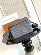 Louis Vuitton monogram crossbody bag, gray with black shoulder strap and logo print.