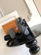 Louis Vuitton monogram crossbody bag in gray with black strap and front flap detail.