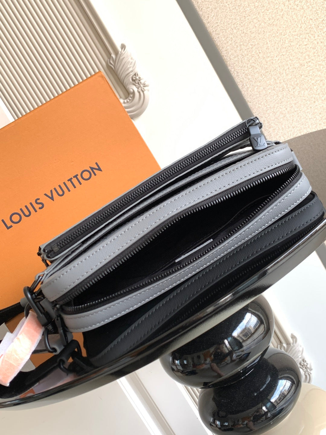 Louis Vuitton monogram crossbody bag with double zipper, light gray leather and logo hardware.