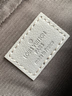 Louis Vuitton logo patch on gray fabric, stitched label detail.