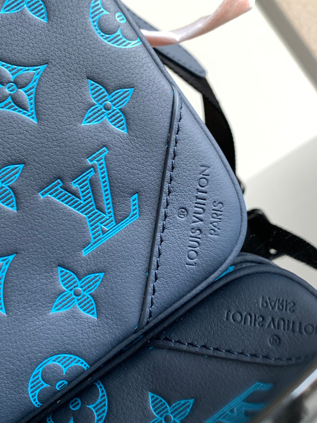 Blue monogram leather bag panel with embossed LV lettering and flower motifs