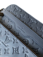 Dark blue leather crossbody bag close-up of embossed monogram pattern