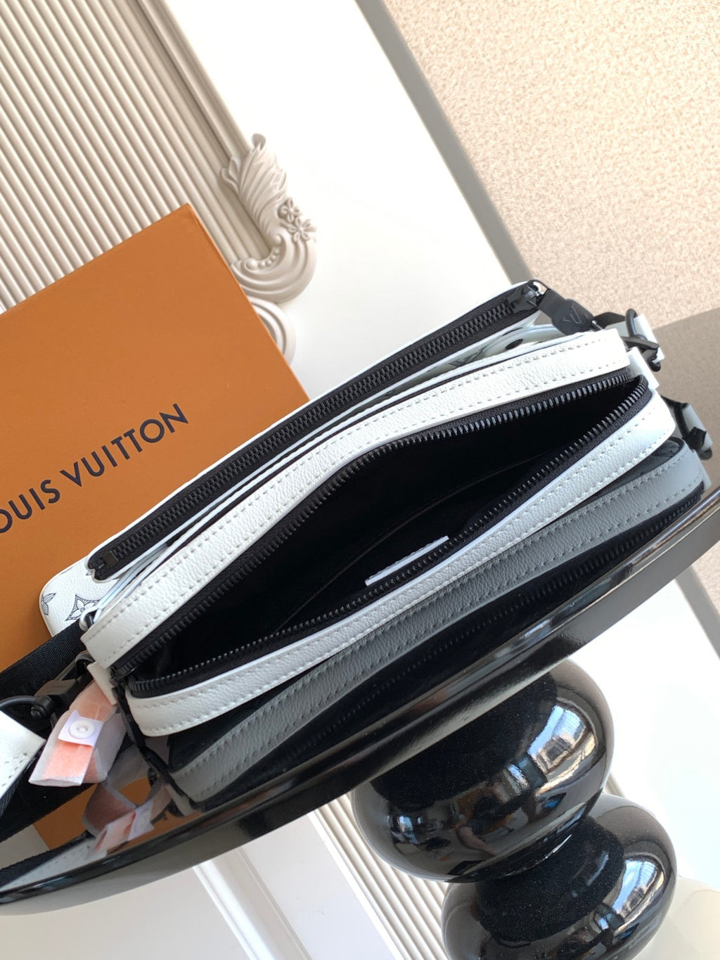 Crossbody bag zipper close-up with light blue trim and black main compartment