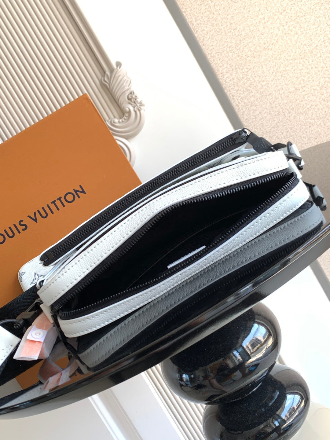 Crossbody bag zipper close-up with light blue trim and black main compartment