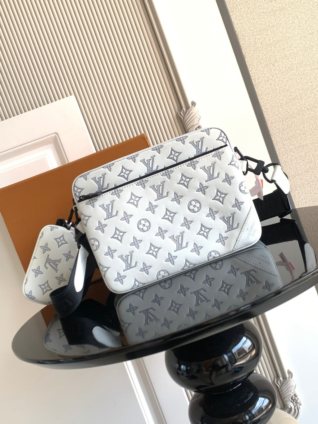 Louis Vuitton crossbody bag with blue monogram pattern, black strap and zipper front