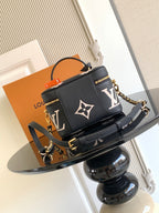 Louis Vuitton mini bag with black leather base, white monogram, and gold hardware