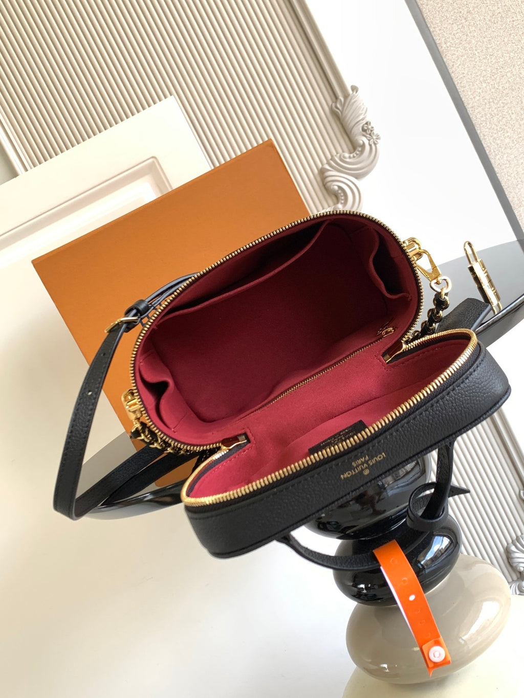 Louis Vuitton mini crossbody bag open view, showing red interior and gold-trim zipper