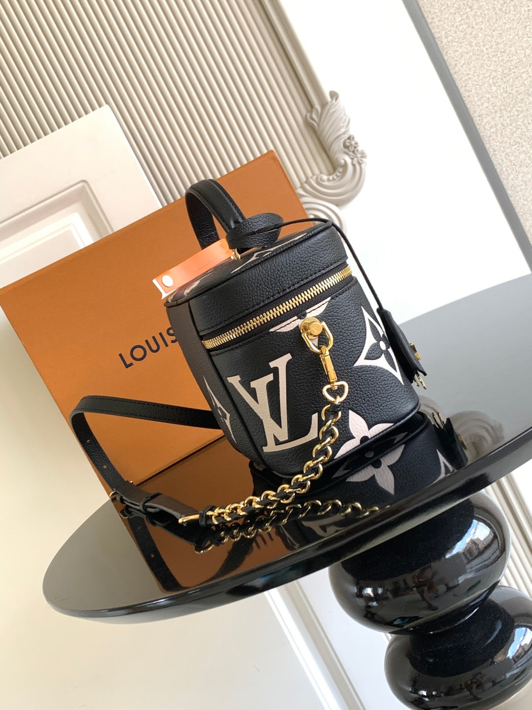 Louis Vuitton mini crossbody bag in black with white monogram, gold zipper and chain