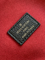 Louis Vuitton label card on black leather with “Louis Vuitton Paris” text