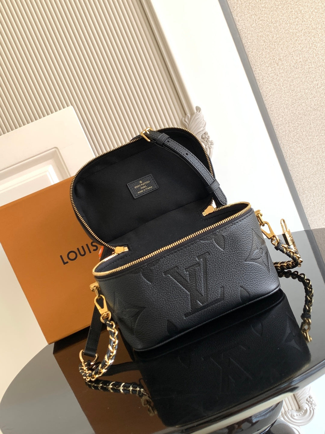 Black Louis Vuitton mini crossbody bag with flap top, chain strap, and gold hardware