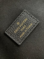 Black leather Louis Vuitton card holder label with gold embossed logo