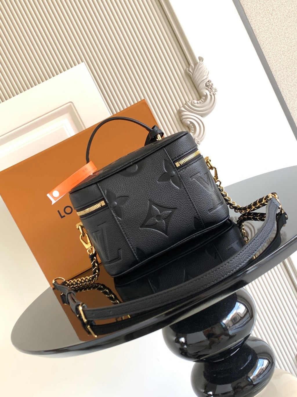 Black Louis Vuitton mini crossbody bag with embossed monogram and chain shoulder strap