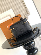 Black Louis Vuitton mini crossbody bag with embossed monogram and chain shoulder strap