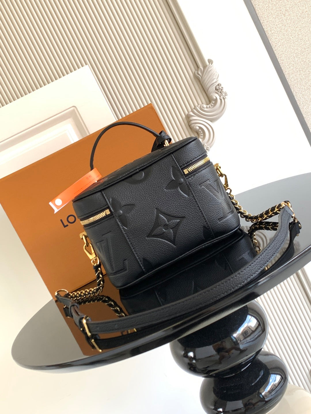 Black Louis Vuitton mini crossbody bag with embossed monogram and chain shoulder strap