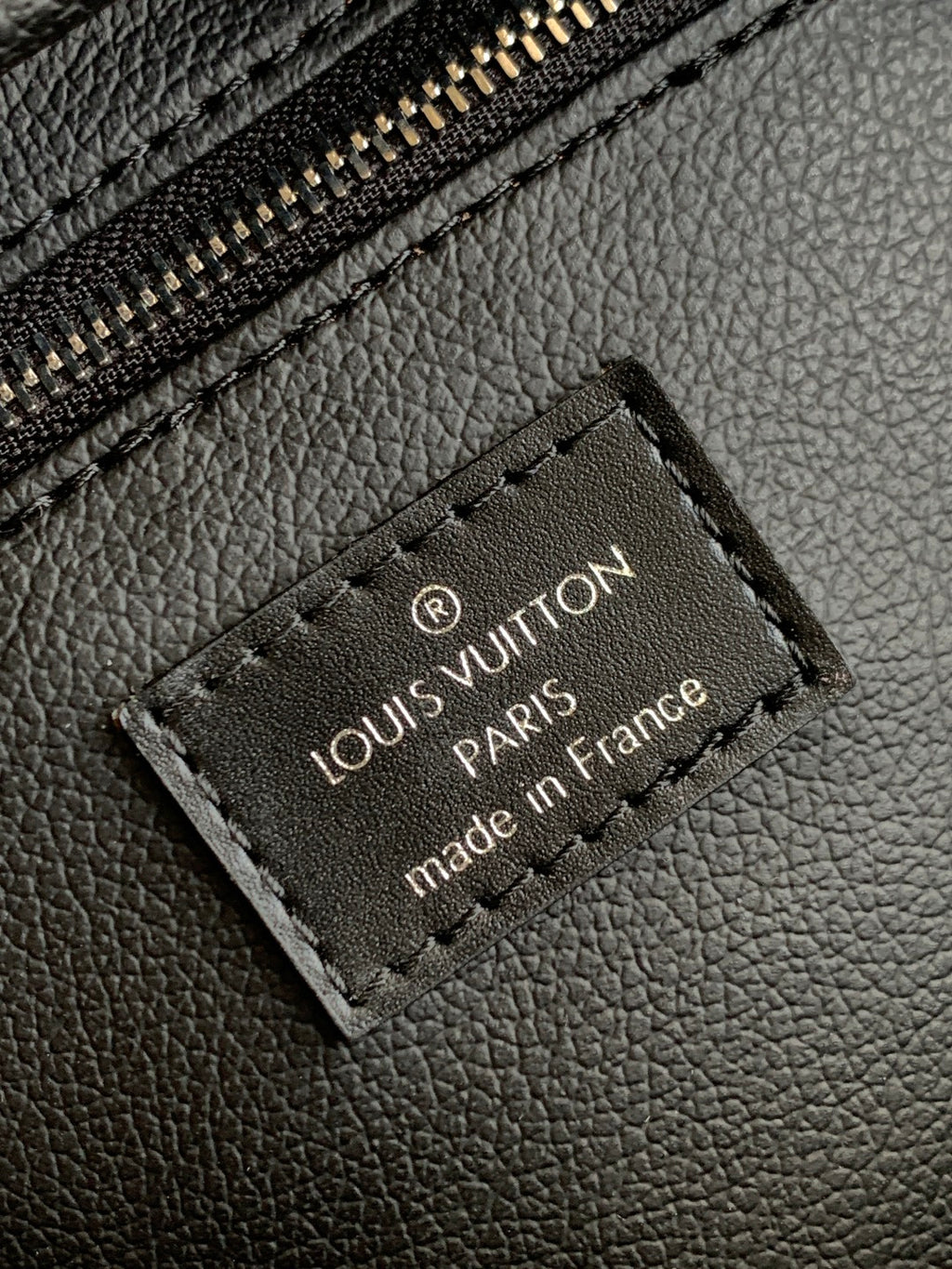 Louis Vuitton leather logo patch reading 'PARIS' and 'made in France' on black bag