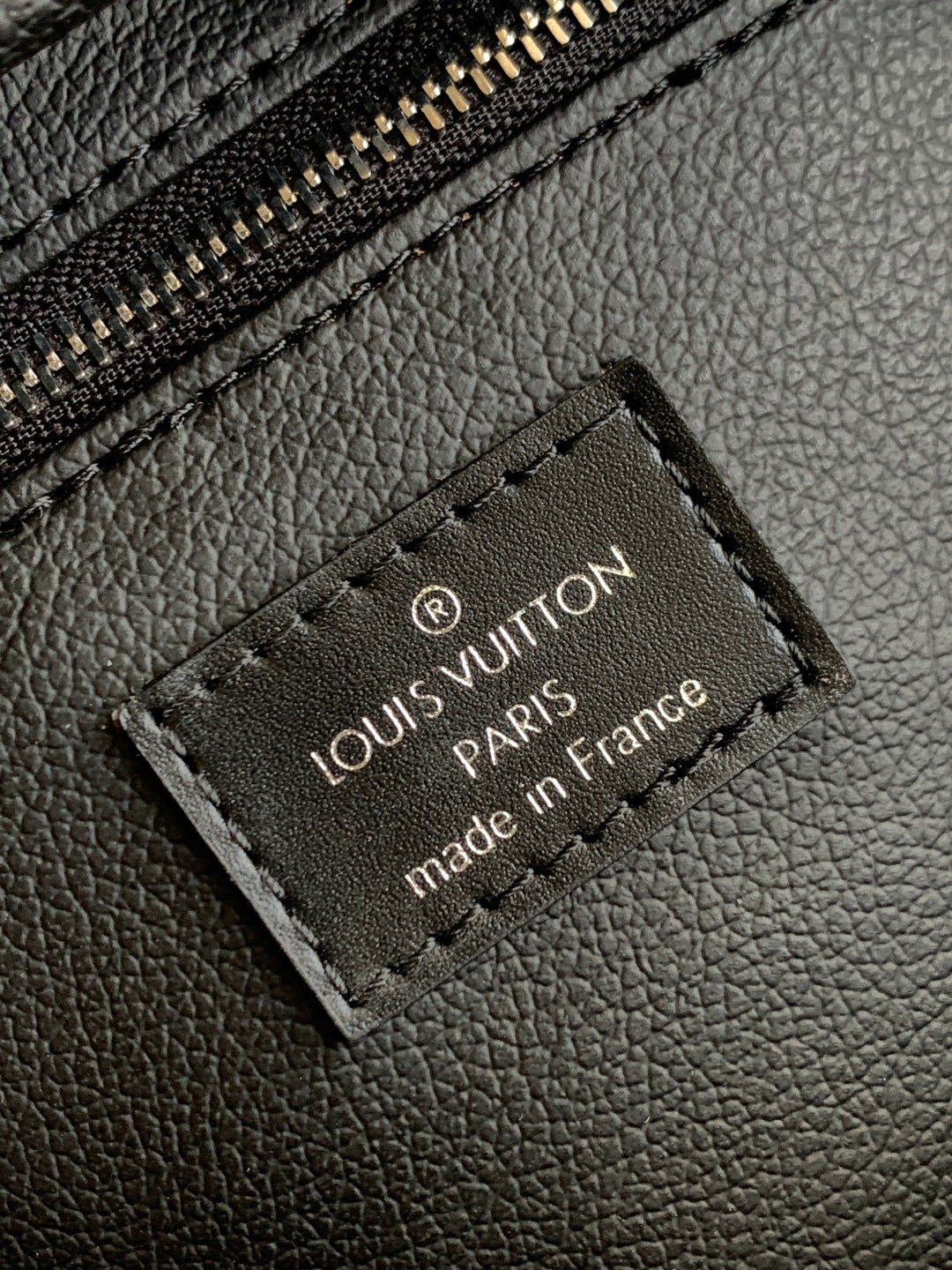 Louis Vuitton leather logo patch reading 'PARIS' and 'made in France' on black bag