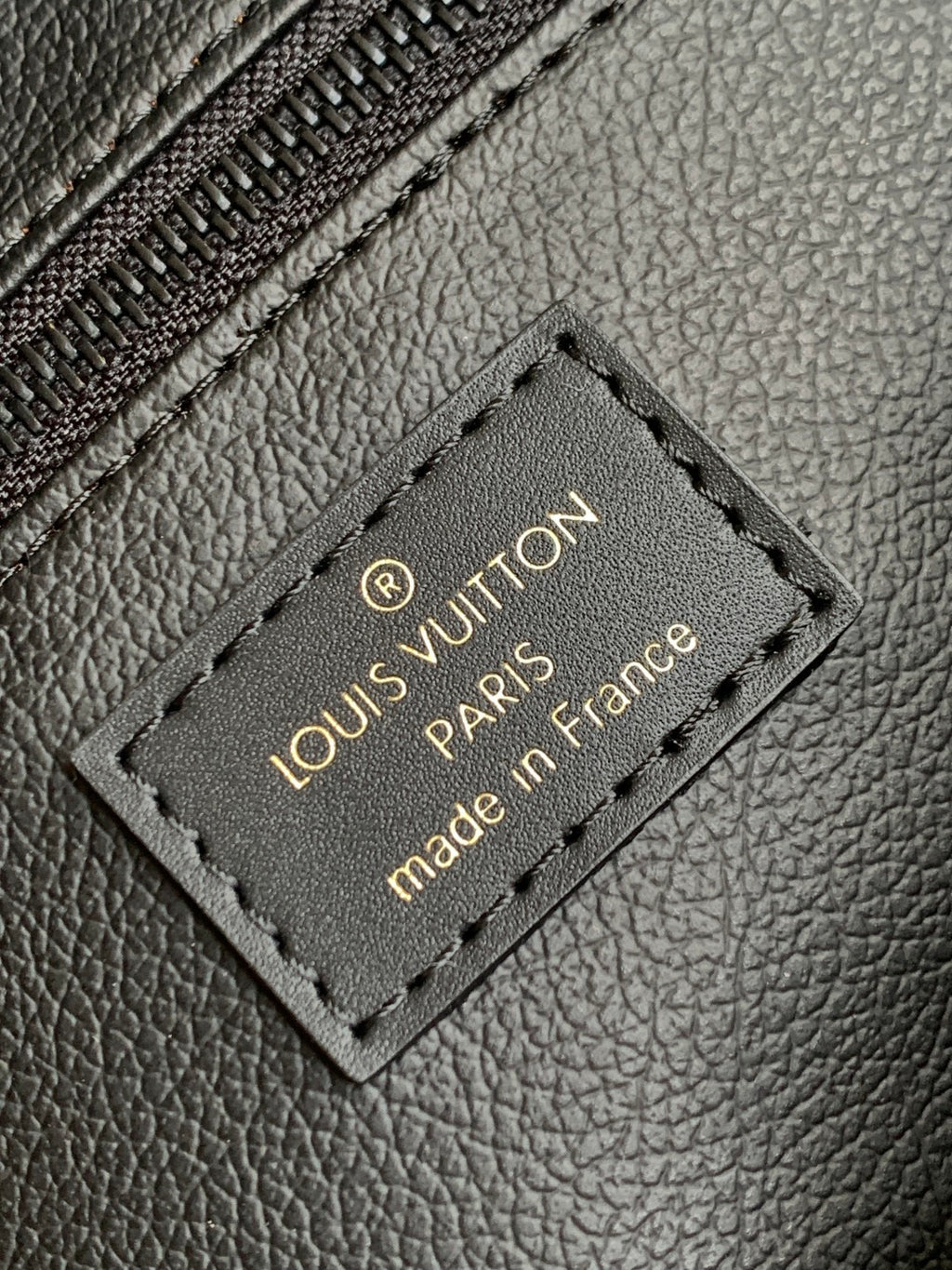 Louis Vuitton leather patch label reading “Louis Vuitton Paris” and “made in France”