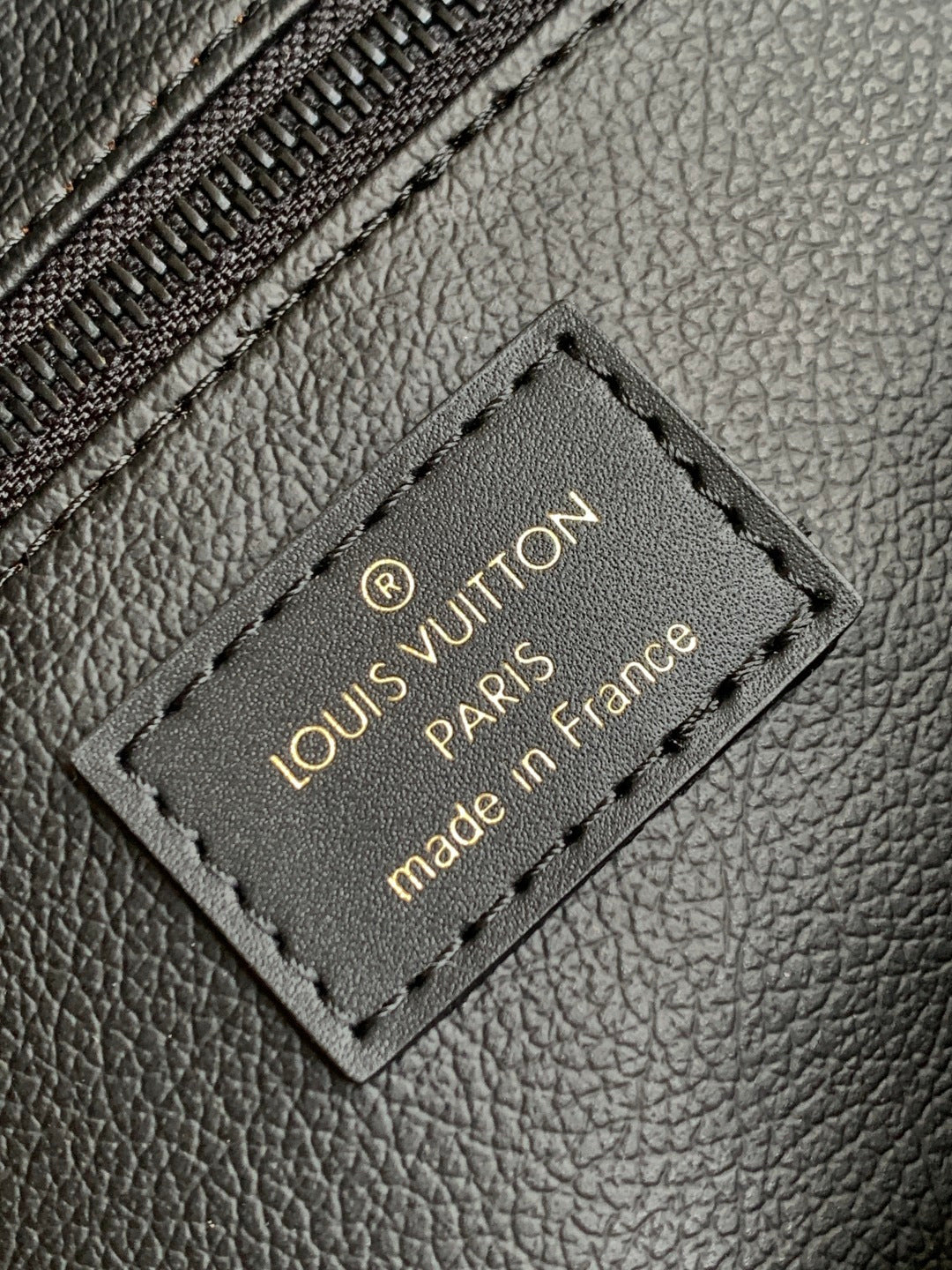 Louis Vuitton leather patch label reading “Louis Vuitton Paris” and “made in France”
