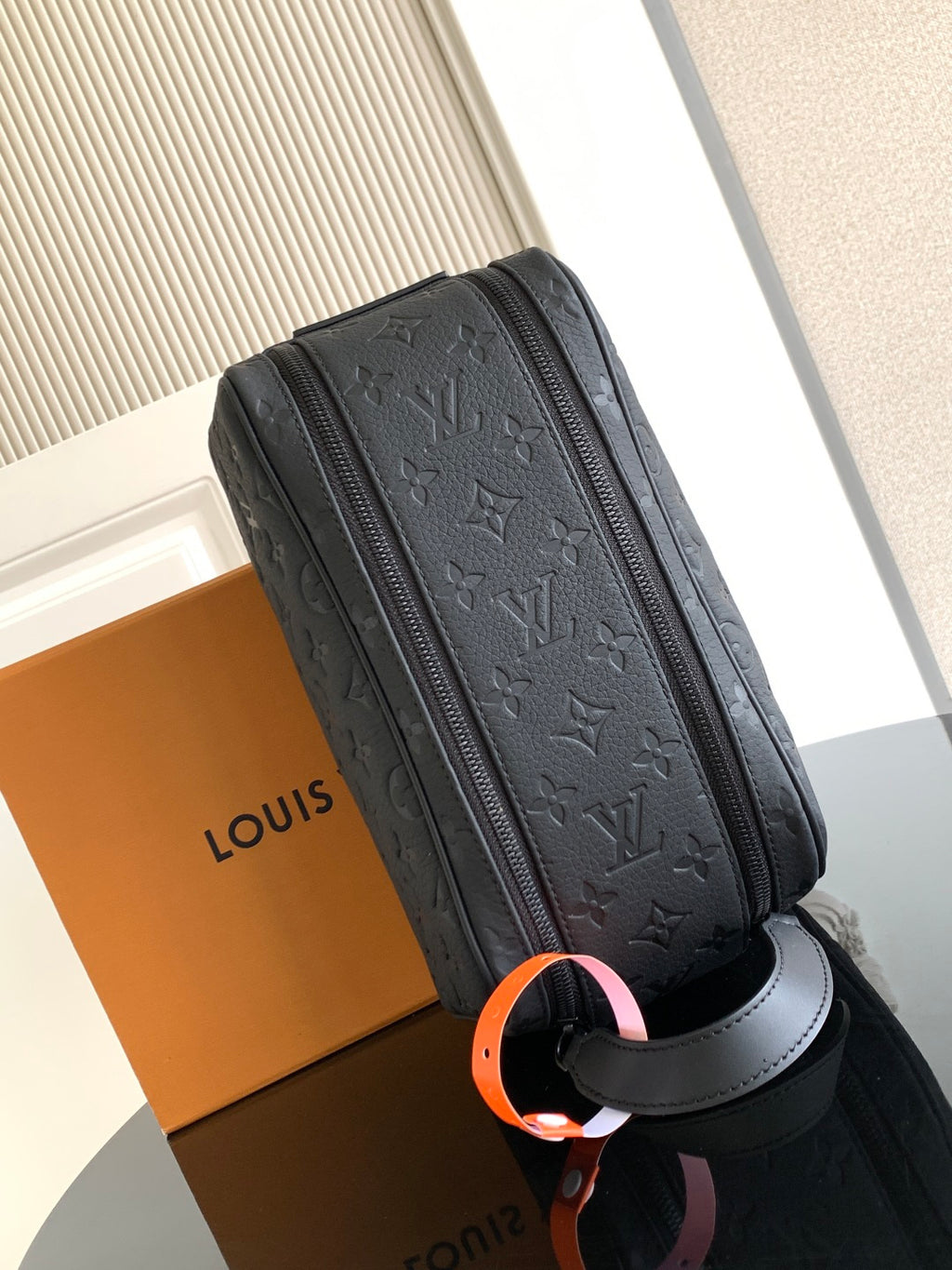 Louis Vuitton bag with dark monogram texture, center zipper, and cross strap