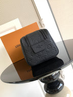 Louis Vuitton bag with dark monogram texture, front patch detail, and top zipper
