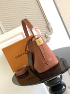 Louis Vuitton leather tote bag with shoulder strap, padlock clasp, and top handles