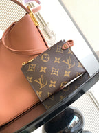 Louis Vuitton monogram canvas pouch on pink leather tote, with gold-tone zipper top
