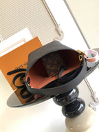 Black leather bucket bag open to reveal brown monogram lining and interior.