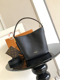 Black leather bucket bag with top handle and gold-tone hardware, open top.