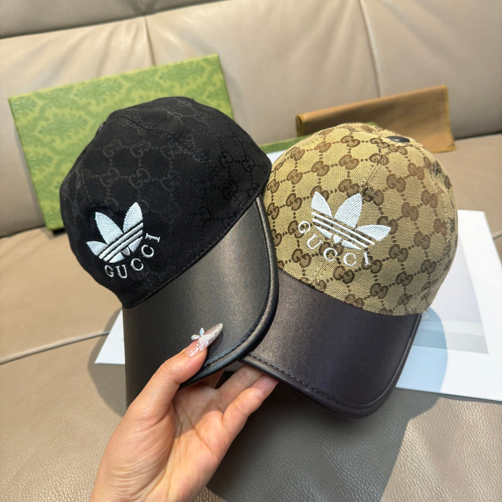 Two Gucci caps: black monogram cap and beige GG canvas cap with blue flower logos