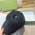 Black GG-print baseball cap with round crown button and curved brim.