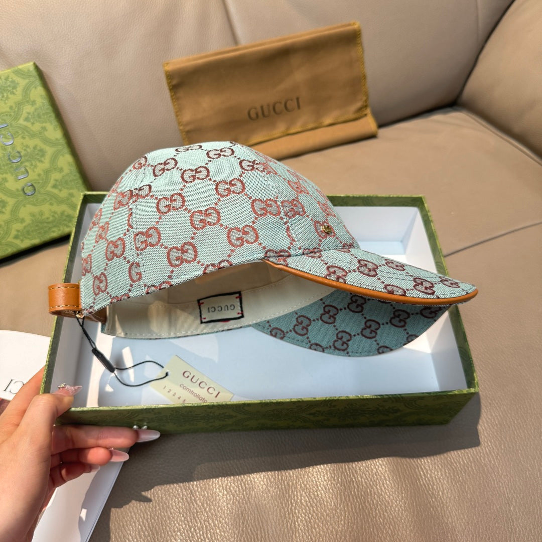 Gucci cap in light blue with red GG monogram pattern, tan leather strap details.