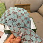 Gucci cap in light blue with red GG monogram pattern, close-up of crown and brim.