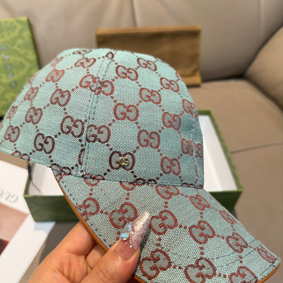 Gucci cap in light blue with red GG monogram pattern, close-up of crown and brim.