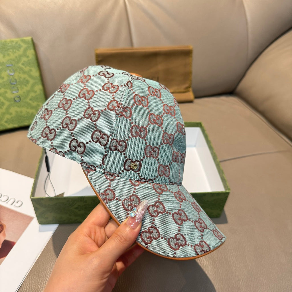 Gucci cap in light blue with red GG monogram pattern, shown from side while held.
