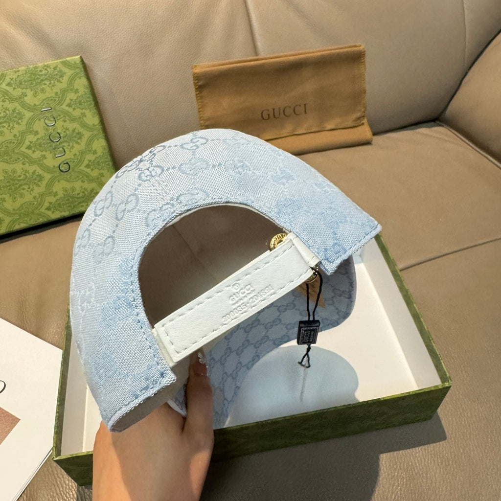 Gucci cap in light blue GG monogram with adjustable strap and brass button closure.