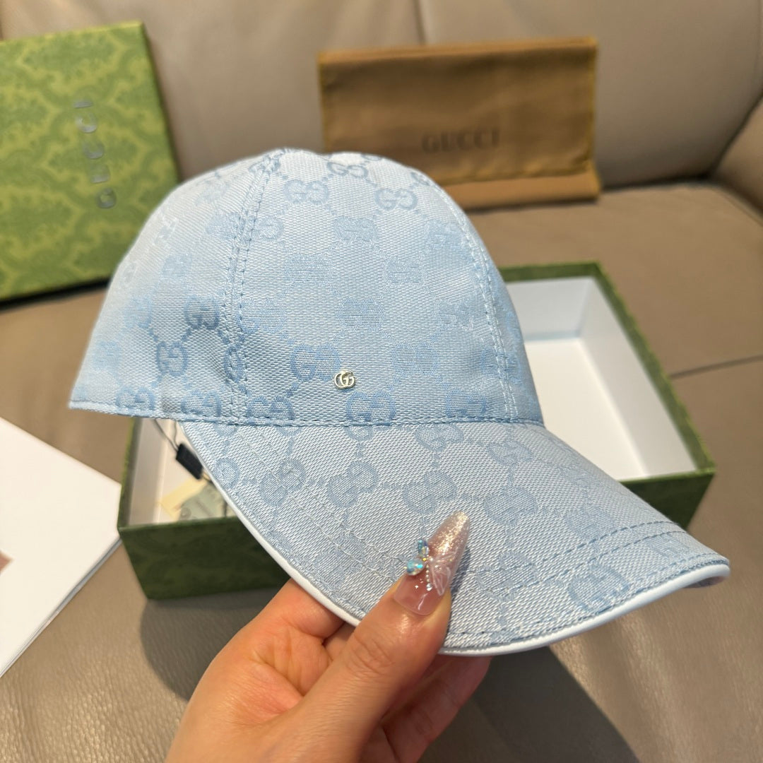 Gucci cap in light blue GG monogram with embroidered logo detail and curved brim.