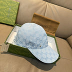 Gucci cap in light blue GG monogram pattern with curved brim and side view.