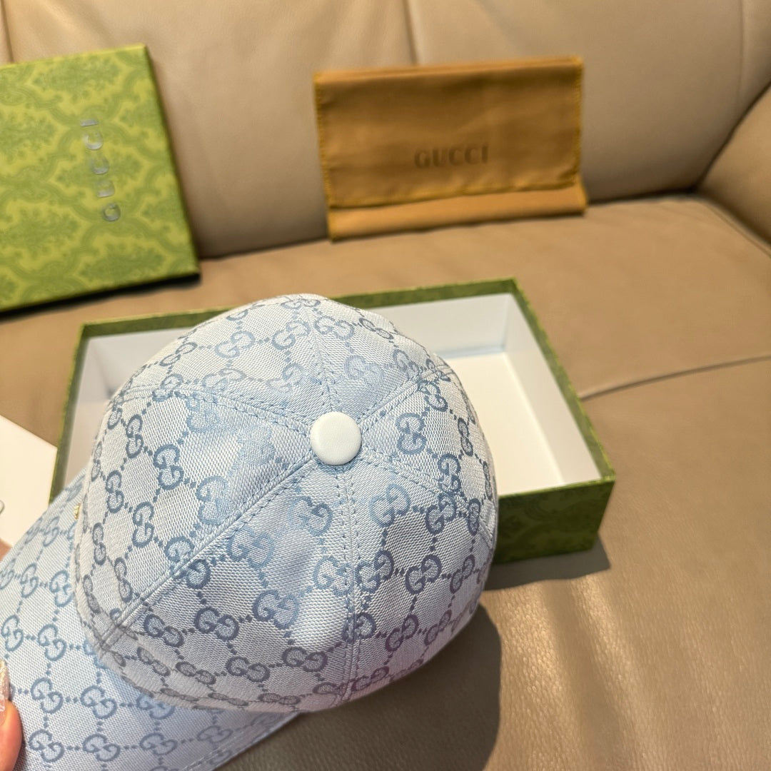 Gucci cap in light blue GG monogram pattern with circular top button and curved brim.