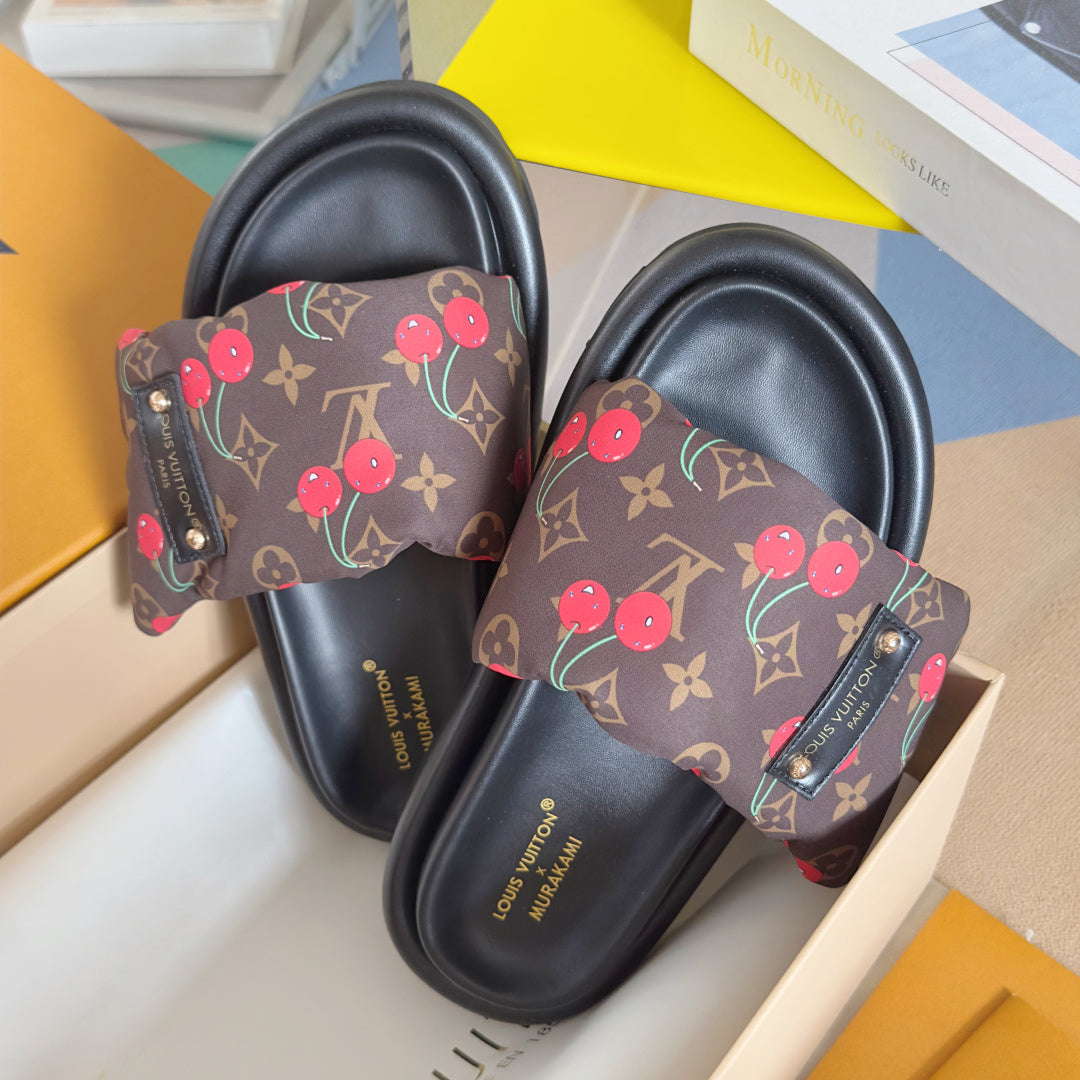 Louis Vuitton slide sandals close-up: dark monogram canvas with red cherries on the straps