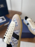 Dior sneaker side view: cream suede with blue monogram panel and white lace