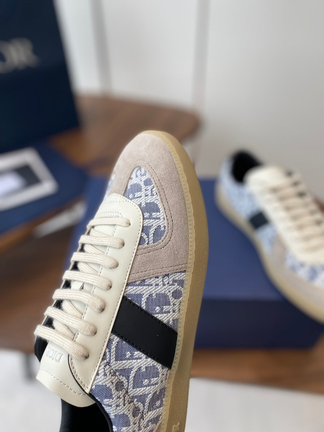 Dior sneaker side view: cream suede with blue monogram panel and white lace