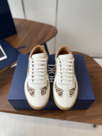 Pair of Dior unisex sneakers in white with tan monogram panel and white laces